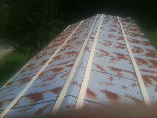 Rusted metal roof panels with new wood purlins before replacement — Storm Damage Roof Repair in Lakeville by Roofing Brothers